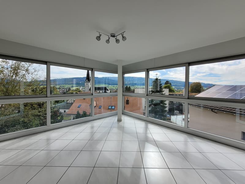 spacious, modern room with large windows, balcony, tiled flooring, view of town and mountains