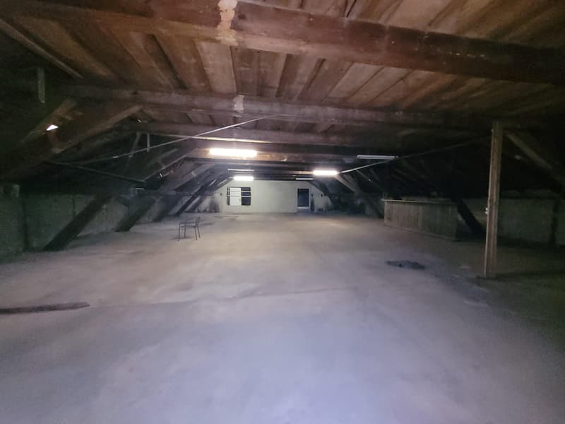 empty room, wooden ceiling, metal beams, concrete floor, small chair, two windows