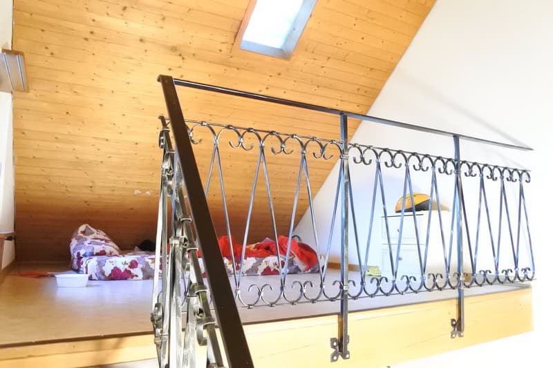 elevated deck with railings, wooden floors, wooden ceiling, a small white cabinet, two pillows, an empty bowl, a window, and a skylight