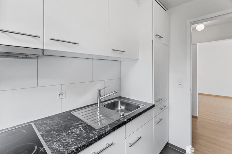 modern kitchen with white cabinets, marble countertop, stainless steel sink, faucet, electrical outlet, and power outlet