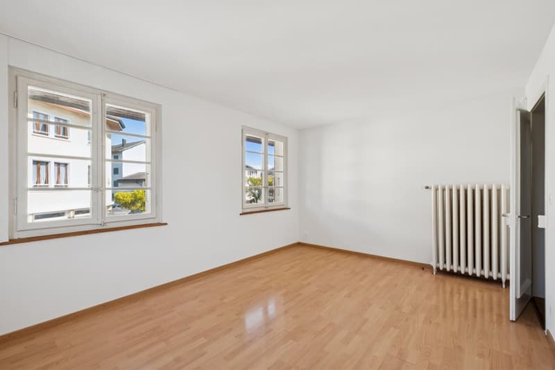 empty room, wooden floor, white walls, two windows, white radiator