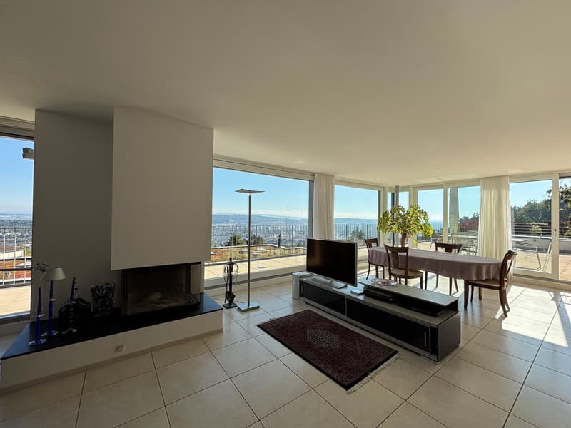 modern living room with white floor, white curtains, modern white fireplace, TV, coffee table, dining set, and scenic outdoor view