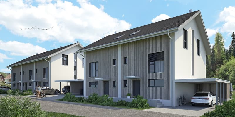 3-story apartment building with a modern, minimalist design. The building has a mix of white and gray exterior with vertical siding. It features large windows, a slanted roof, and a covered parking area in the front. The surrounding area includes trees an