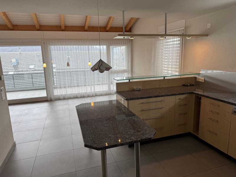 large open room, granite countertop, central island, modern cabinets, sliding glass doors to balcony, tiled floor, wooden beams, hanging decorative lamps