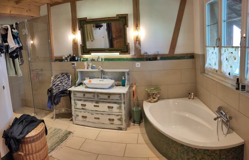 Bathroom with bathtub, sink, mirror, shower, and wooden beams
