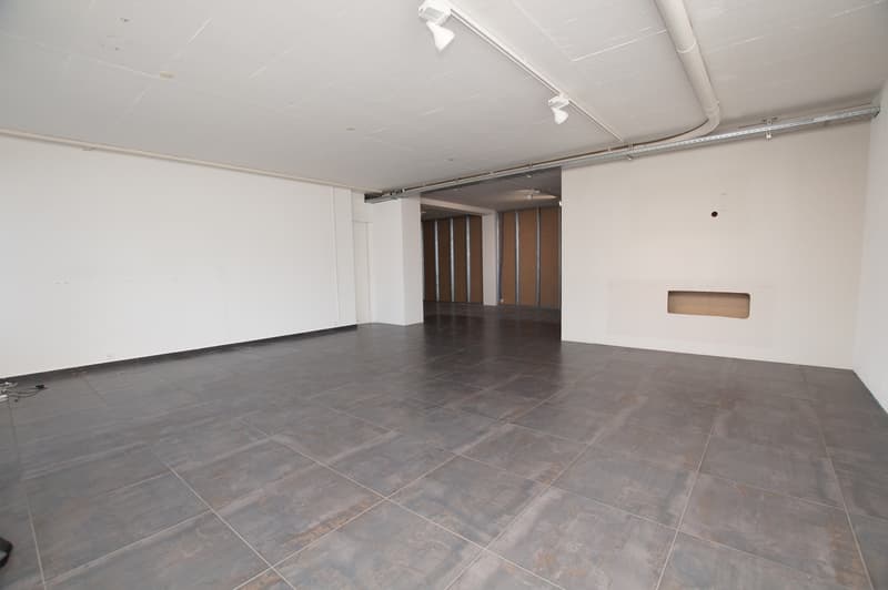 Empty room, tiled floor, white walls, track lighting on ceiling
