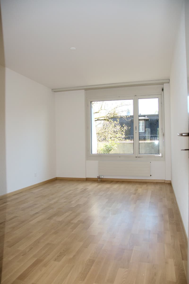 empty room, wooden floor, white walls, large window, radiator