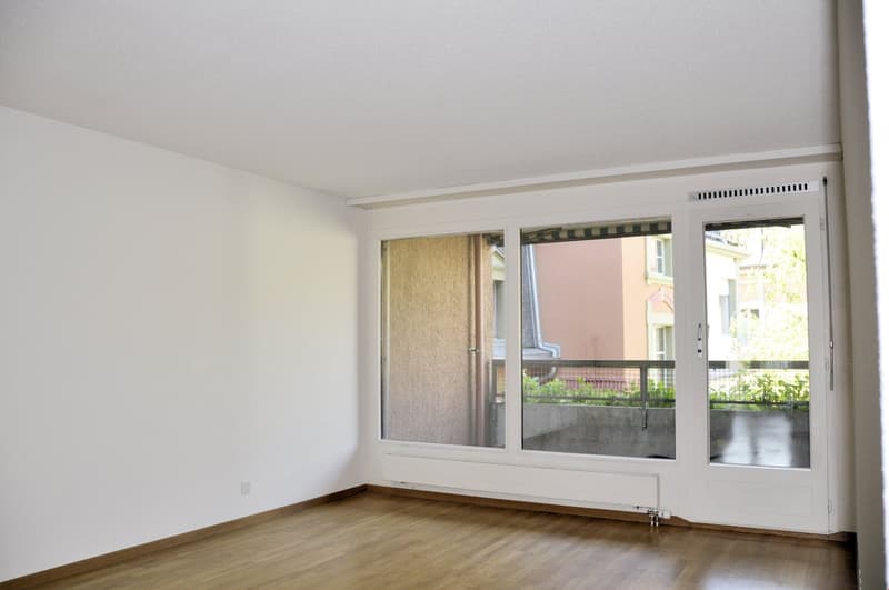 empty room, wooden floor, white walls, sliding glass doors, balcony