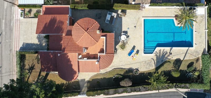 Two-story house with red tile roof, swimming pool, balcony or terrace, and landscaped garden