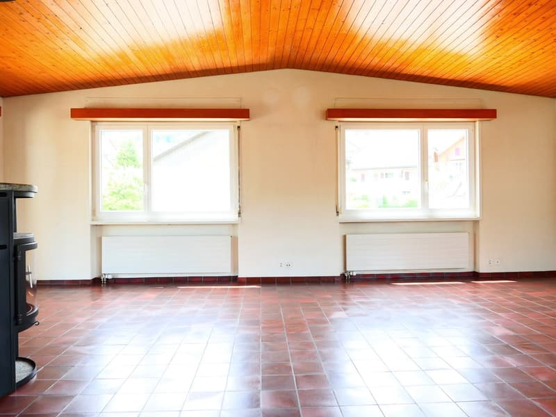 empty room, wooden ceiling, white walls, red tiled floor, two windows, fireplace