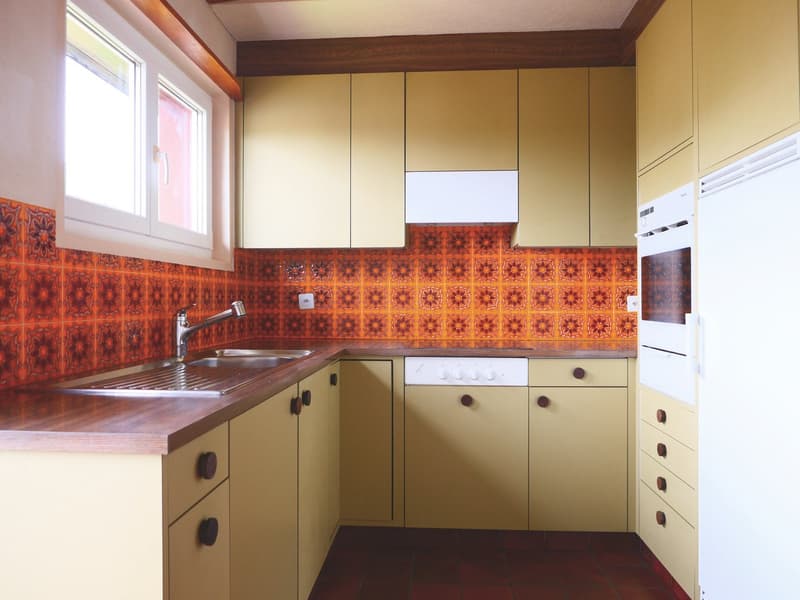 modern kitchen with yellow cabinets, wooden countertops, red tiles, sink, dishwasher, oven, window