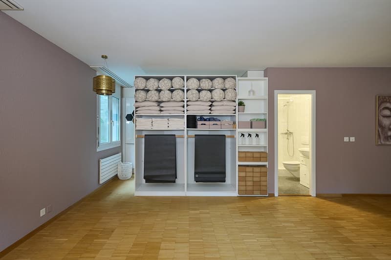 Large wardrobe, yoga mats, towels, baskets, plant, power outlets, wooden flooring