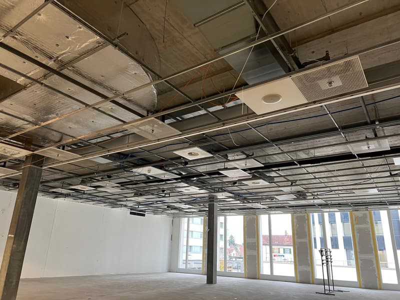 unfinished room with metal beams, exposed wiring, concrete floor, glass windows