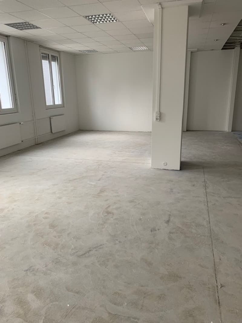 Empty room, white walls, windows, floor, column, pipes, unfinished