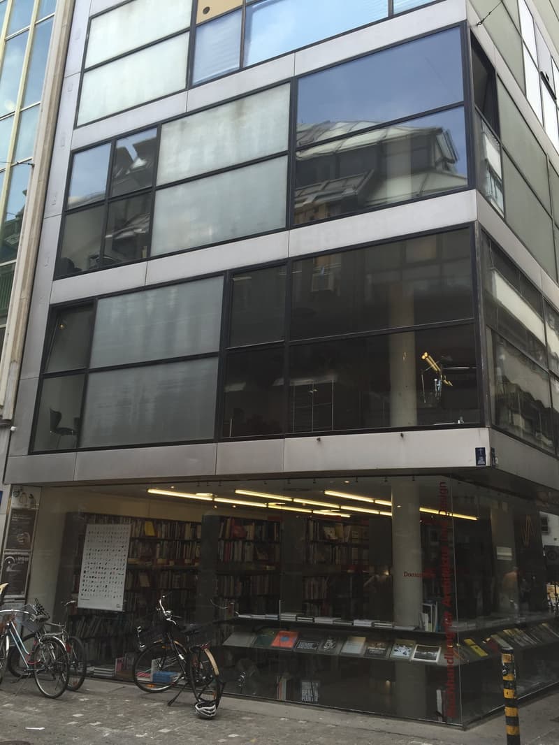 Contemporary building, large windows, steel beams, library on ground floor, bicycles parked outside