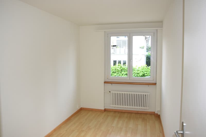 empty room, white walls, wooden floor, white radiator, window with view
