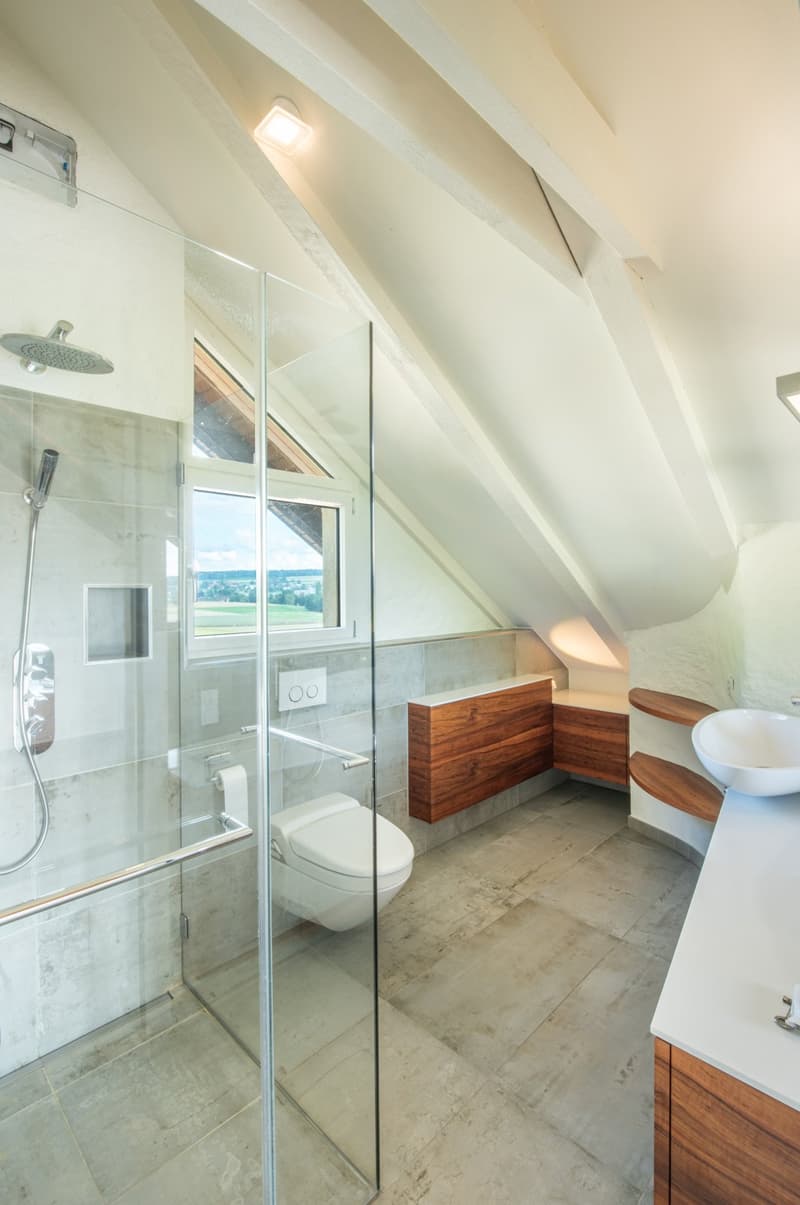 modern shower, large window, wooden wall cabinets, white marble countertop, underfloor heating