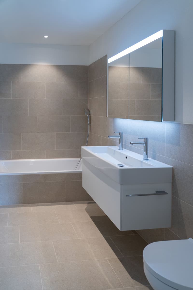 Bathroom with bathtub, sink, mirror, and toilet