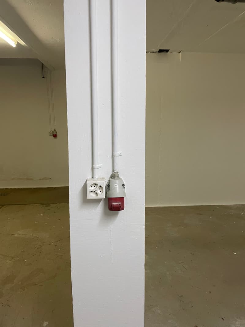 white walls, white ceiling, power outlet, red and white switch, white pillar