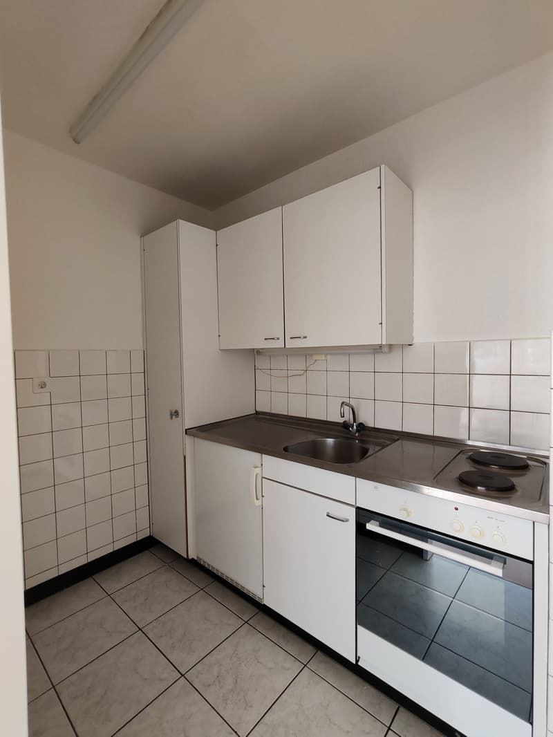 modern kitchen, white cabinets, tiled walls, stainless steel countertop, sink, oven, induction cooktop, light fixtures