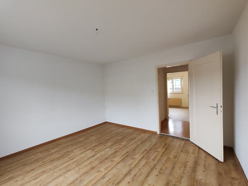 empty room, white walls, wooden floor, door leading to another room