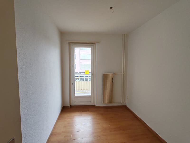 white walls, wooden floor, door leading to outside, white door, glass window