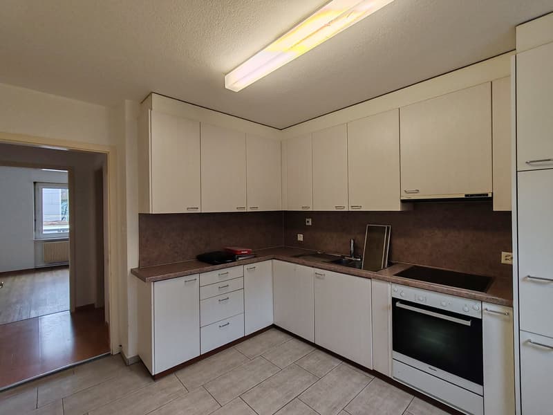 Modern kitchen, white cabinets, brown countertops, white oven, dishwasher, sink, under cabinet lighting