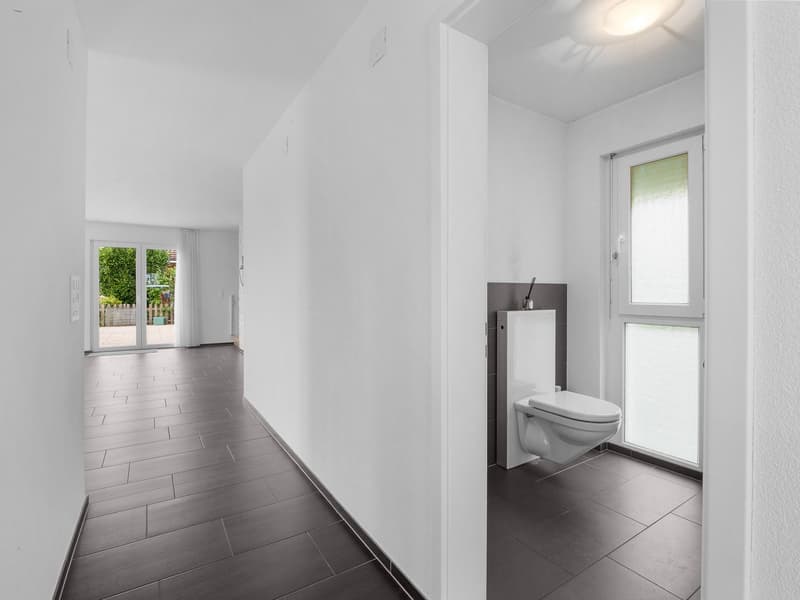 white wall, grey floor, glass door, toilet