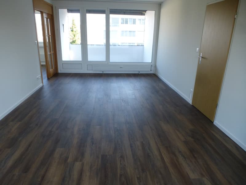 Spacious room, hardwood floors, large windows, high ceiling, no furniture
