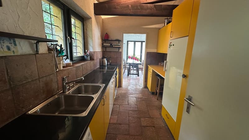 yellow cabinets, black countertops, stainless steel sink, white refrigerator, washing machine