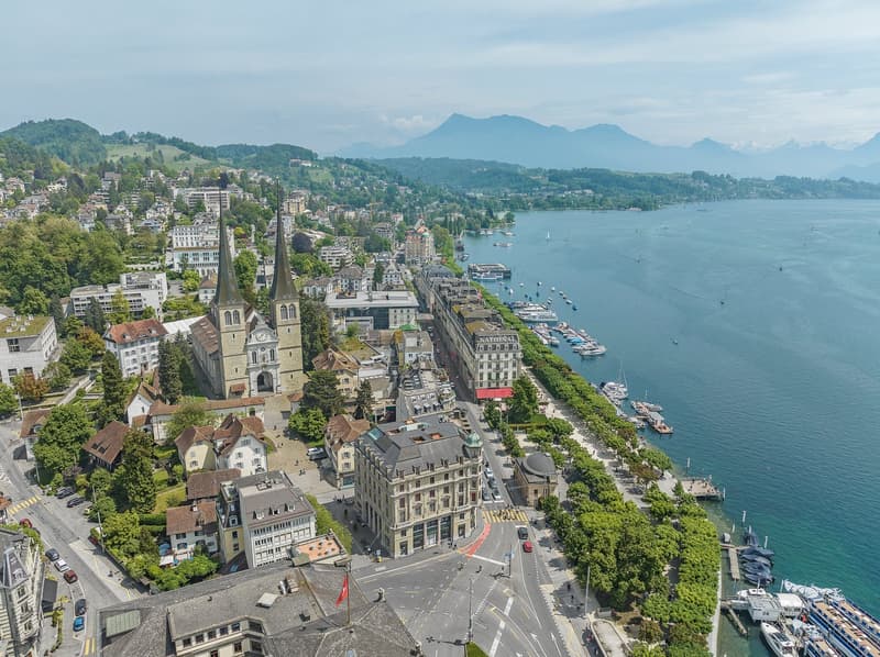 Aerial view of a city by a lake with mountains in the background