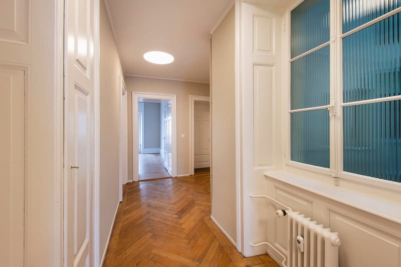 Parquet floor, white walls, large windows, radiator