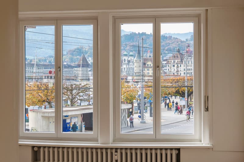 Large triple windows, white walls, overlooking city streets, mountains in the background