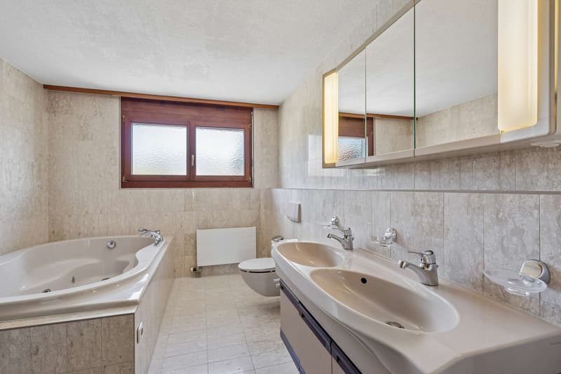 Badezimmer mit Doppellavabo und einladender Whirlpool-Badewanne (1.OG)