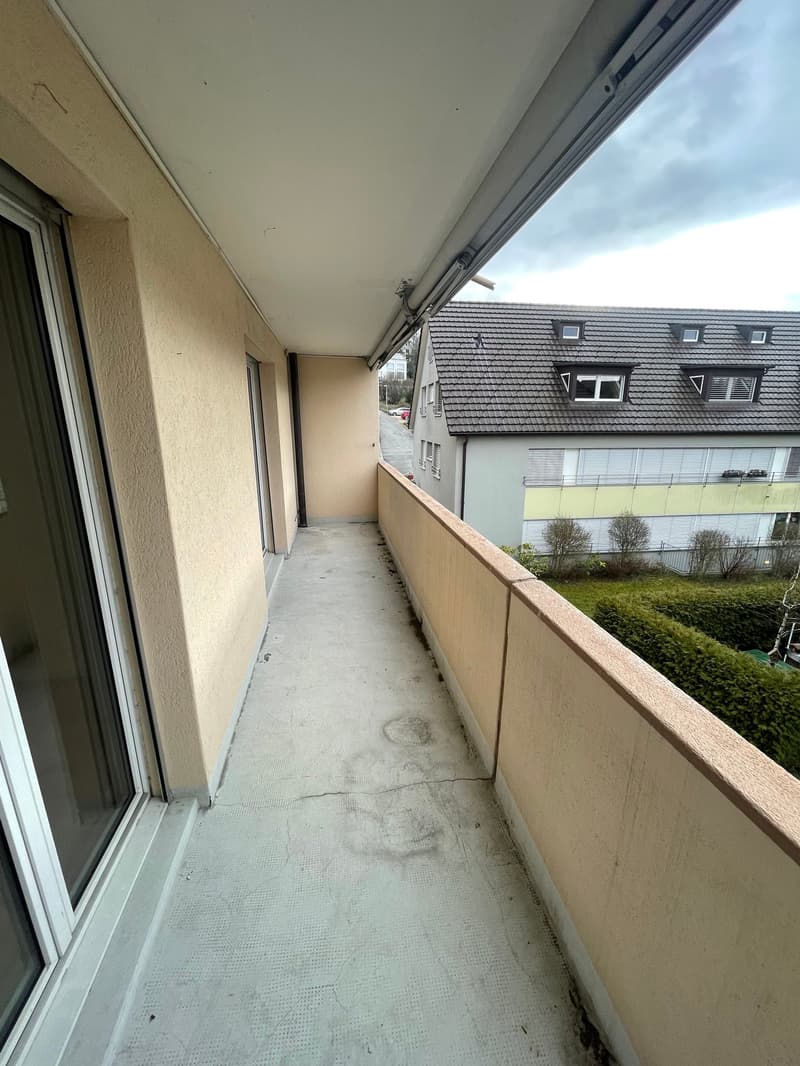 concrete floor, beige walls, glass doors, metal railings
