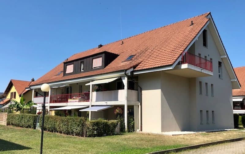 Modern house, 3 stories, brown roof, red balconies, awnings, plants on the balconies