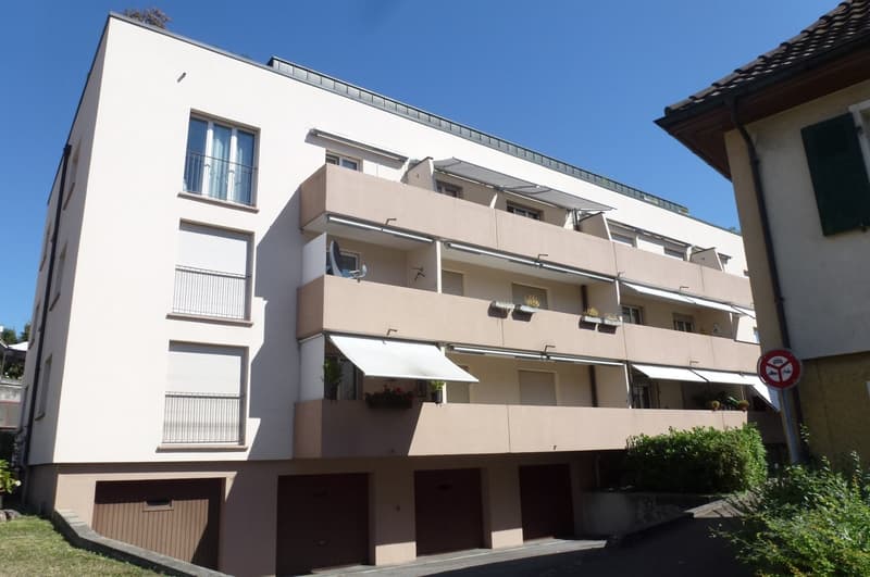 4 story building, white exterior, balconies, awnings, underground garages