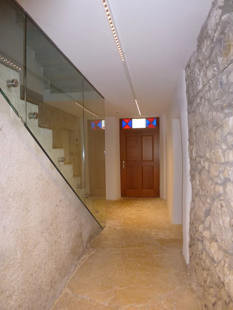 glass railing, wooden door, stone wall, tiled floor