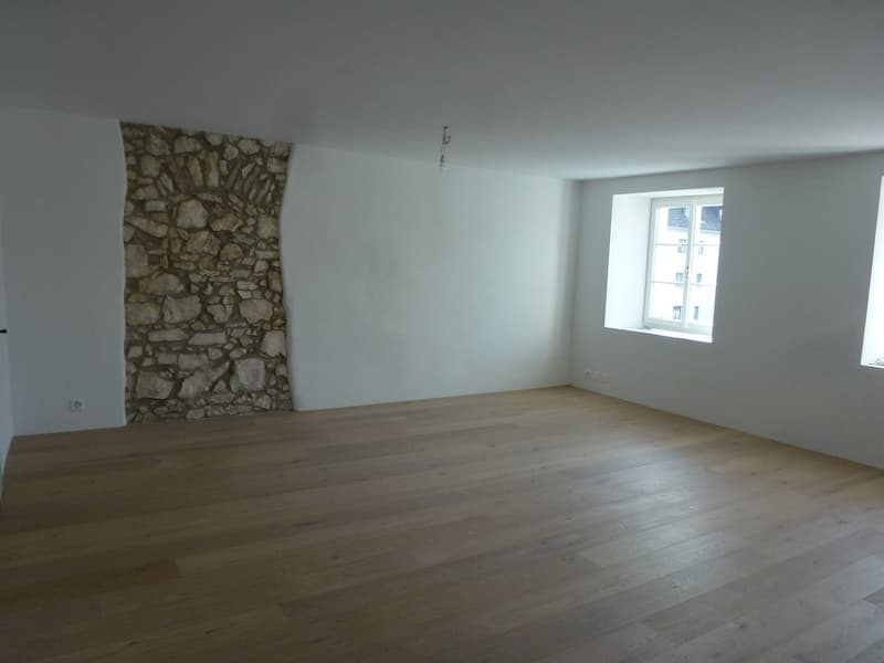 empty room, wooden floor, stone wall, two windows, white walls