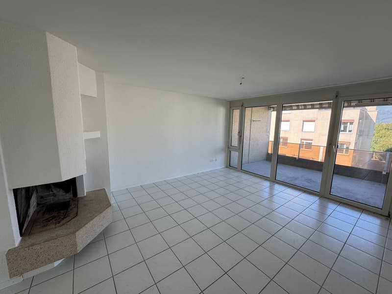 empty room with white tiles, fireplace, sliding glass doors to balcony