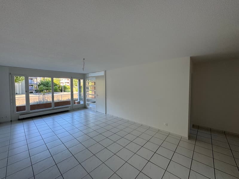 empty room, large windows, balcony with railings, view of outside, tiled floor