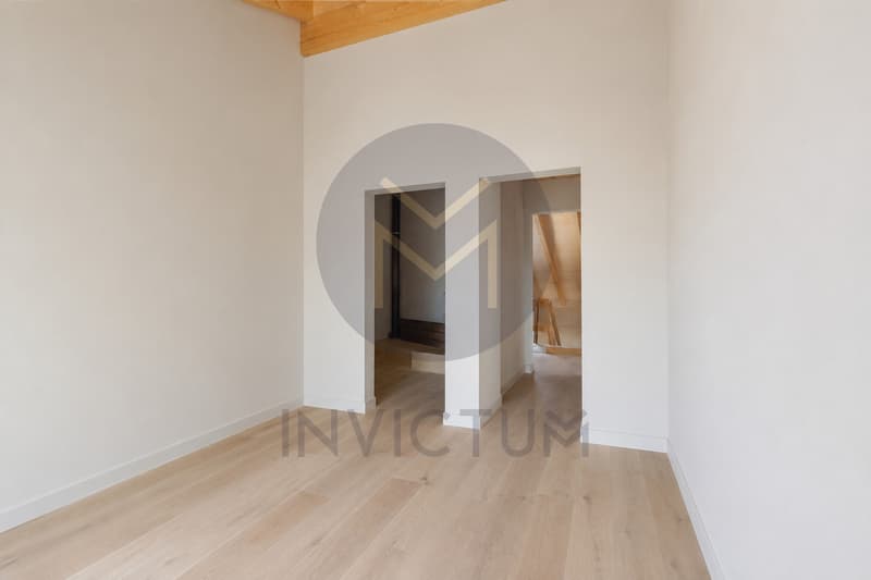 Chambre parentale avec douche attenante / an empty room in a house with white walls and wooden floors