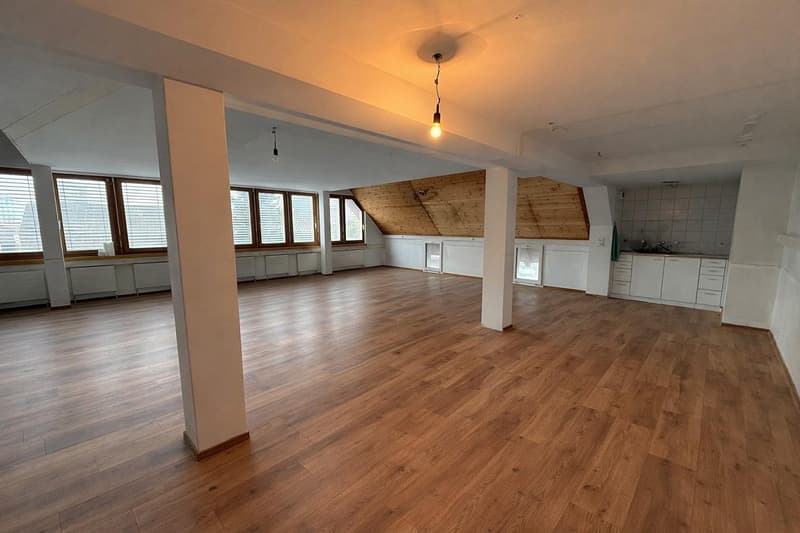 empty room, wooden floor, white walls, large windows, wooden ceiling, kitchen area