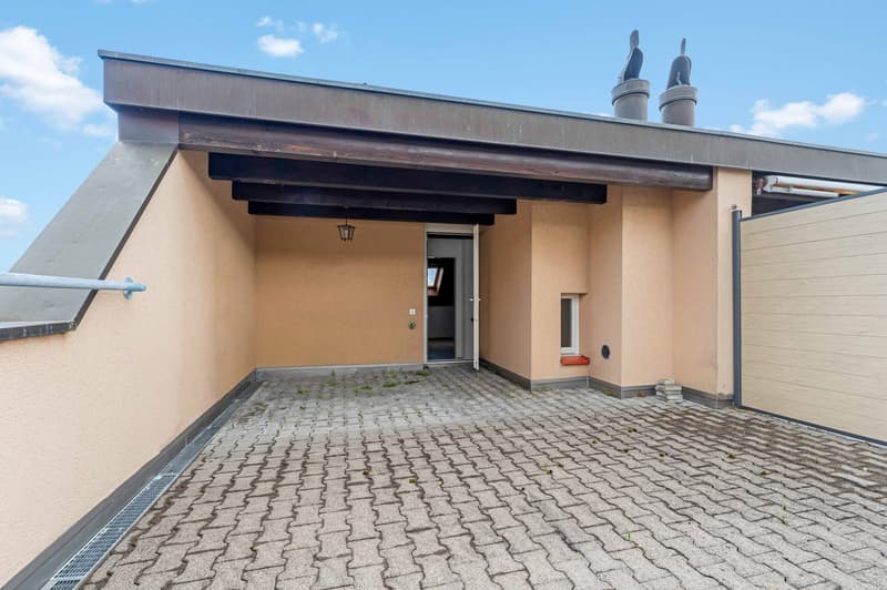 Roof terrace with brick floor, wooden beams, entrance door, small window, lamp