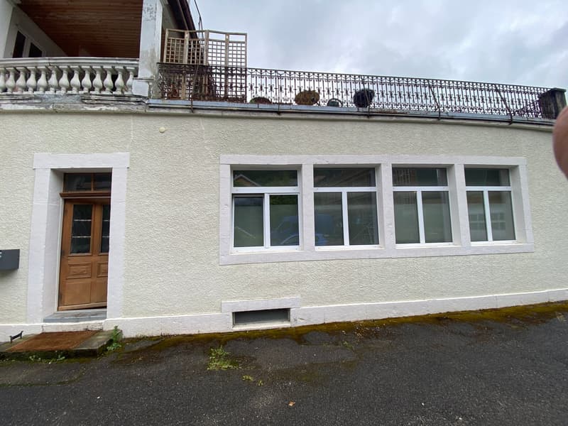 white painted house, wooden door, 4 windows, balcony with metal railings