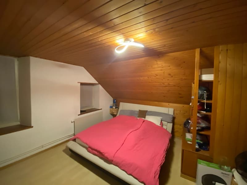 bedroom with bed, wooden ceiling, white walls, wooden wardrobe, small window, radiator