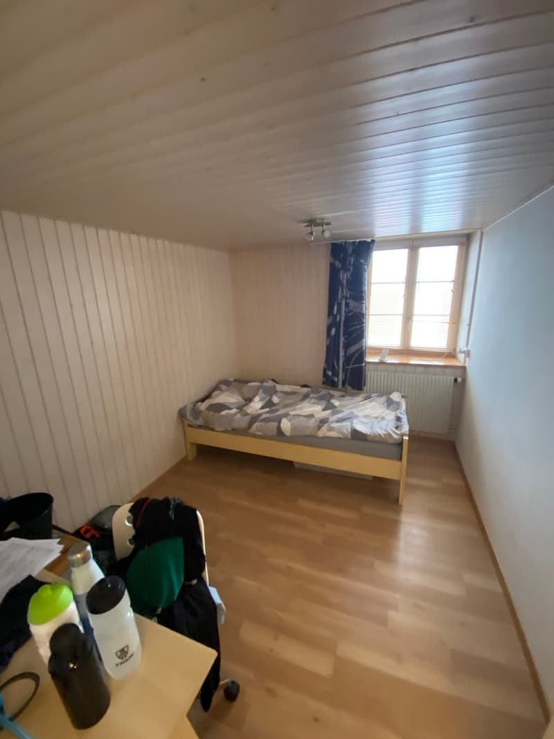 small bedroom with bed, desk, and window