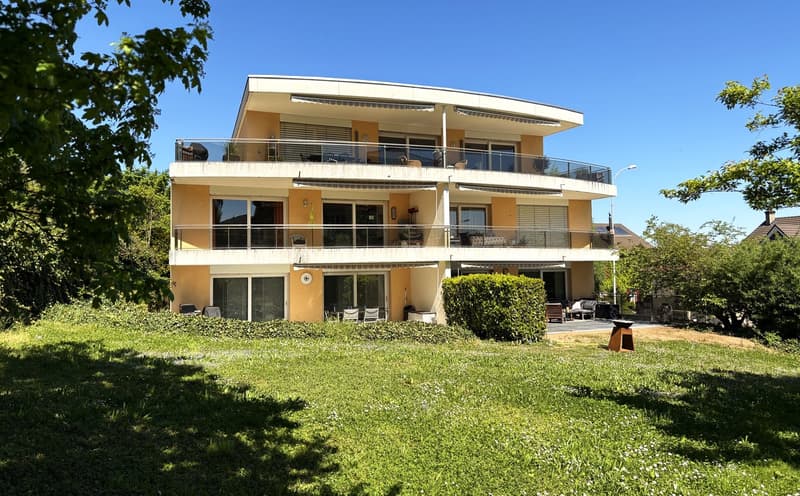 2 story house, yellow exterior, multiple balconies, large windows, surrounded by greenery