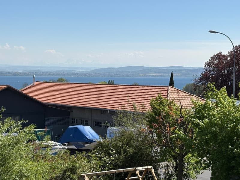 House with red roof, located near the water, with a view of the mountains