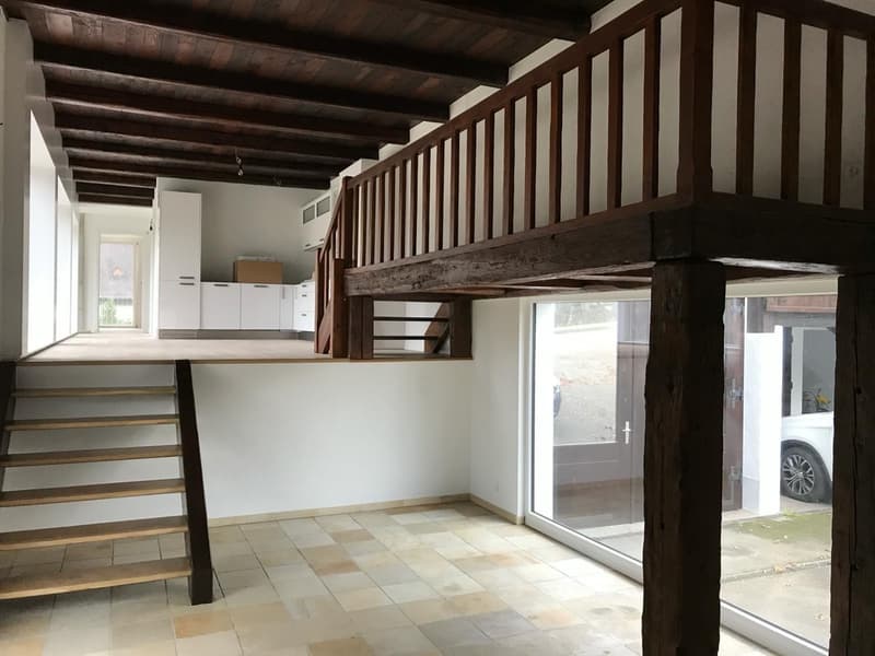 Un bel espace en mezzanine souligné par des poutres apparentes